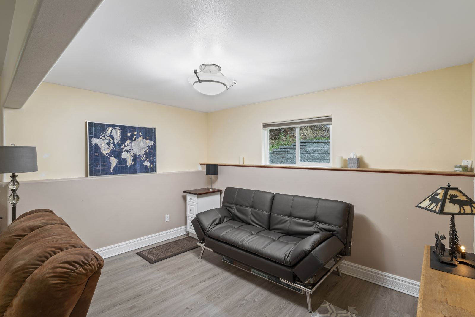 Downstairs room with a futon sofa bed, recliner and world map