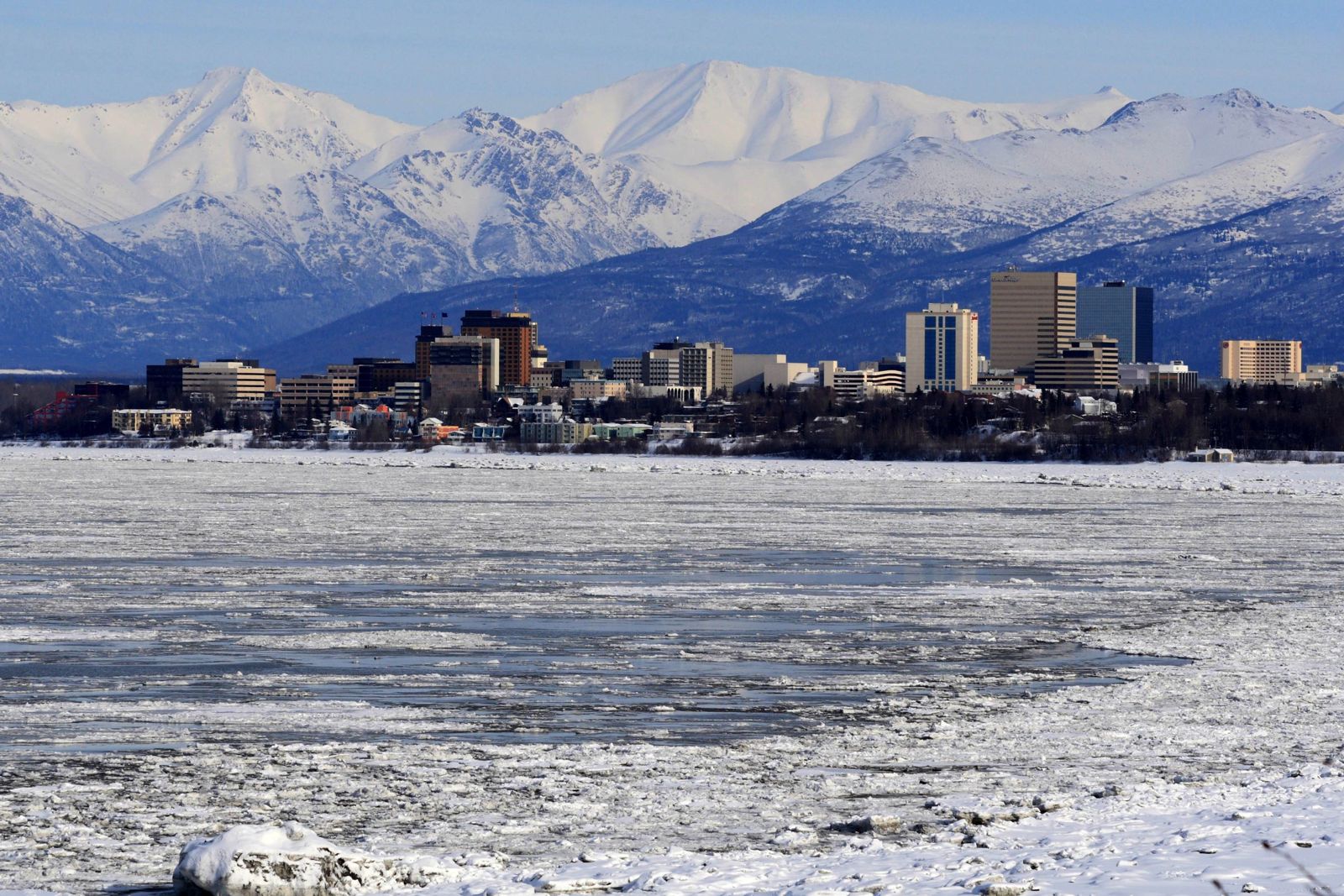 Downtown Anchorage in winter, with ice on Cook Inlet and the snow-covered Chugach Mountains behind