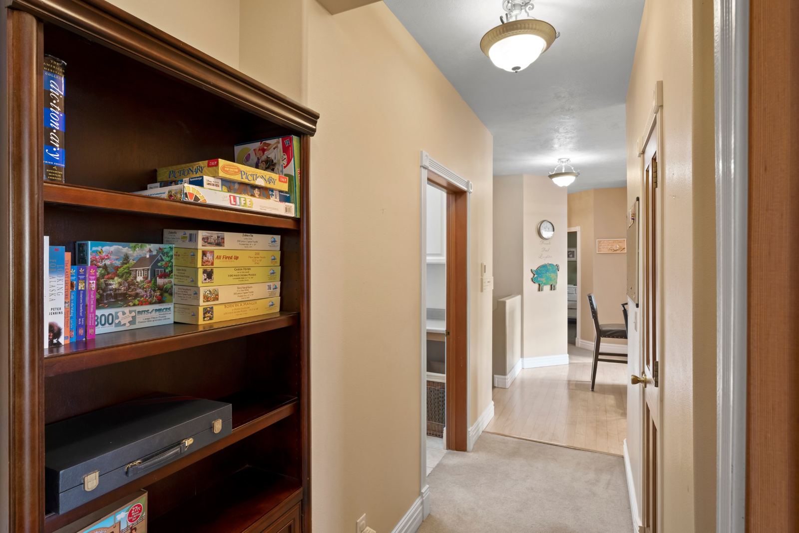 Hallway bookshelf with board games, puzzles and Alaska books