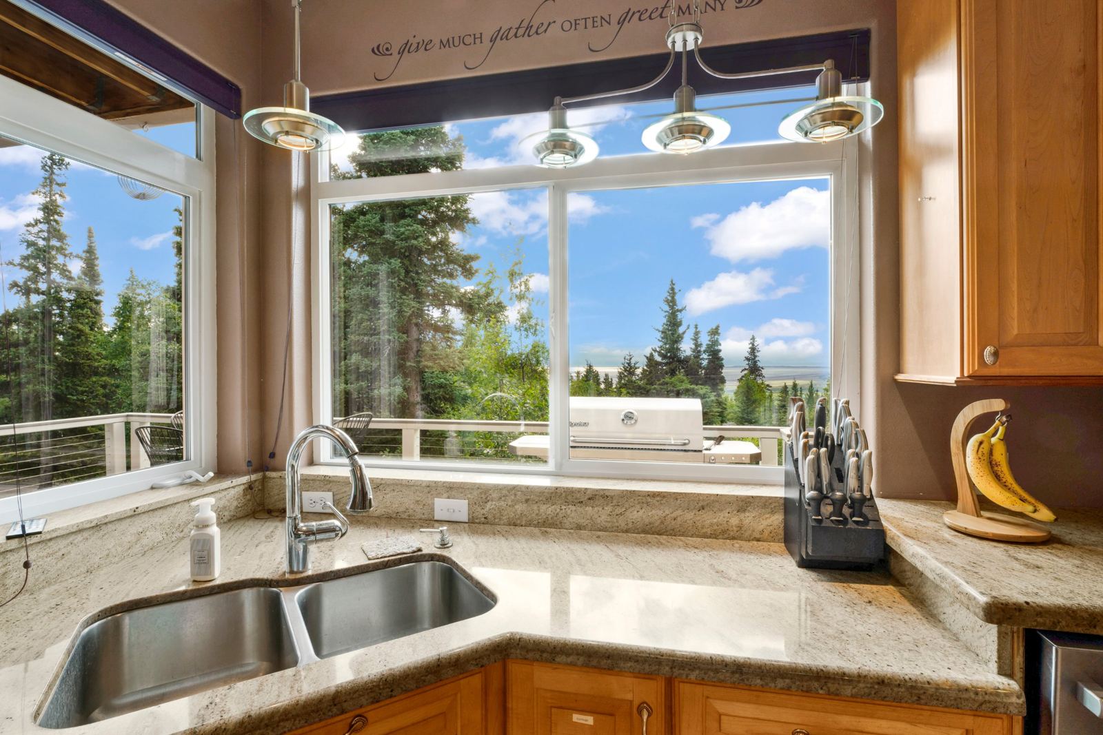 View from the kitchen sink over spruce trees to Cook Inlet