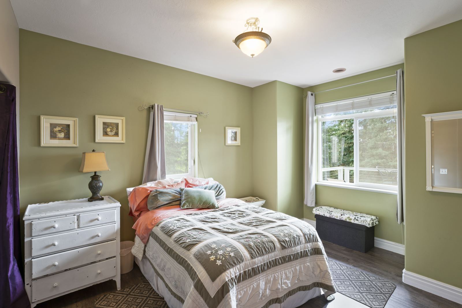 Main-floor bedroom with green walls, white dresser and window seat