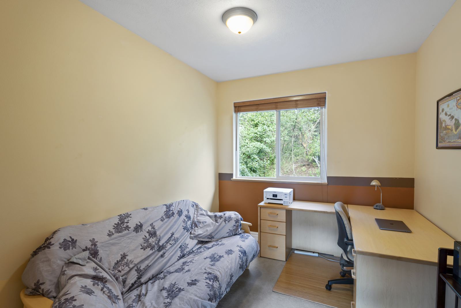 Office with a futon and a desk under a window